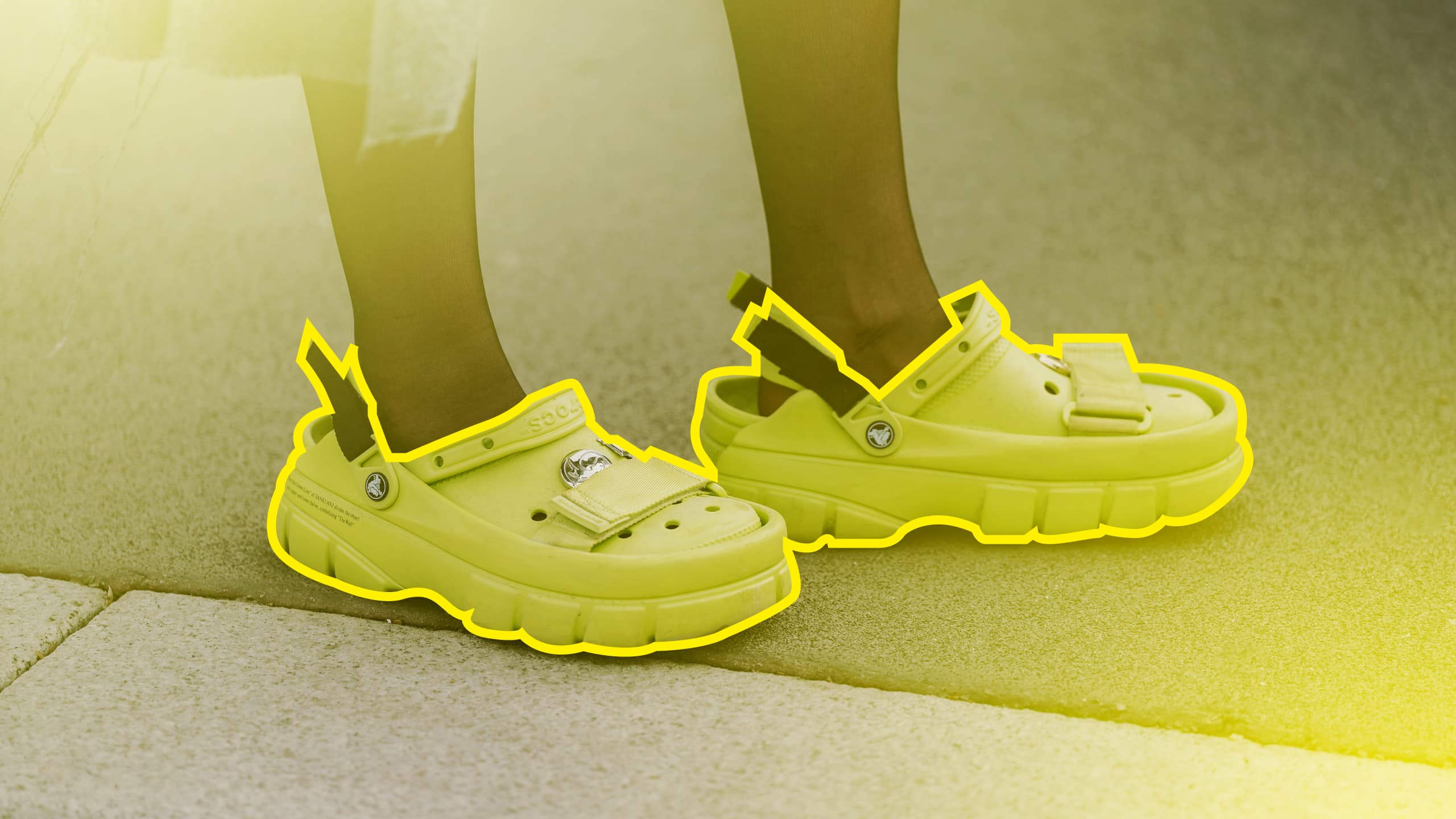 A trendy person wearing Crocs, and the crocs are outlined in yellow