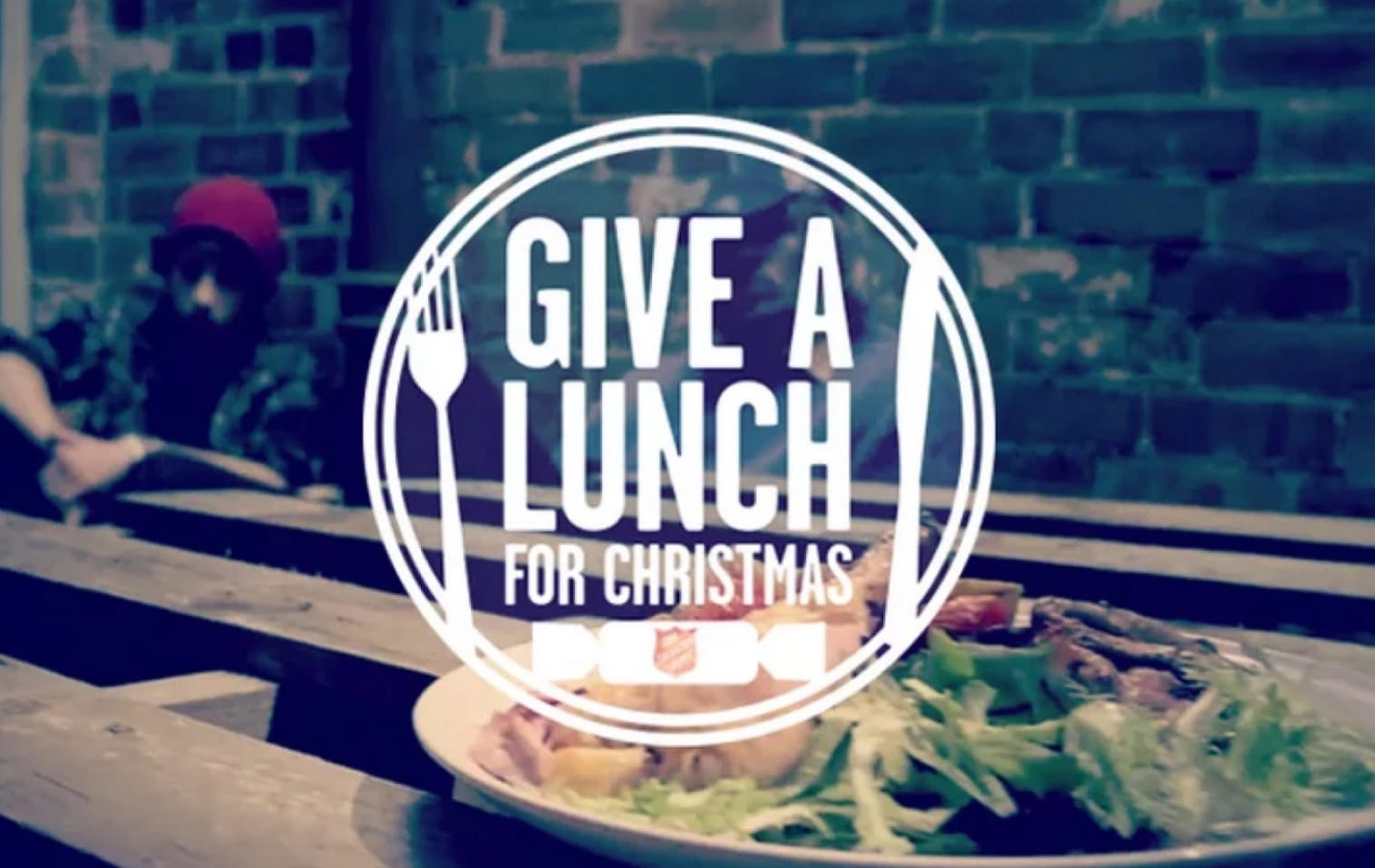 "Give a lunch for Christmas" campaign lockup overlayed on an image of a dinner plate